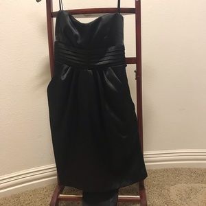 Mini black dress with ribbon attached. The dress has pockets. Never worn.